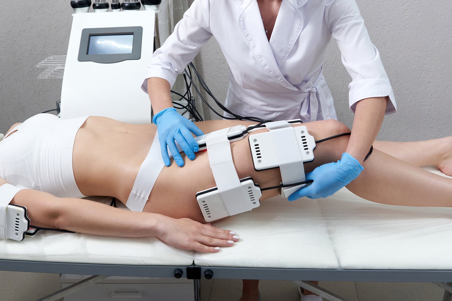 Beautiful woman getting electro stimulation therapy. Laser lipo equipment. Cosmetic fat reduce treatment. Anti cellulite procedure